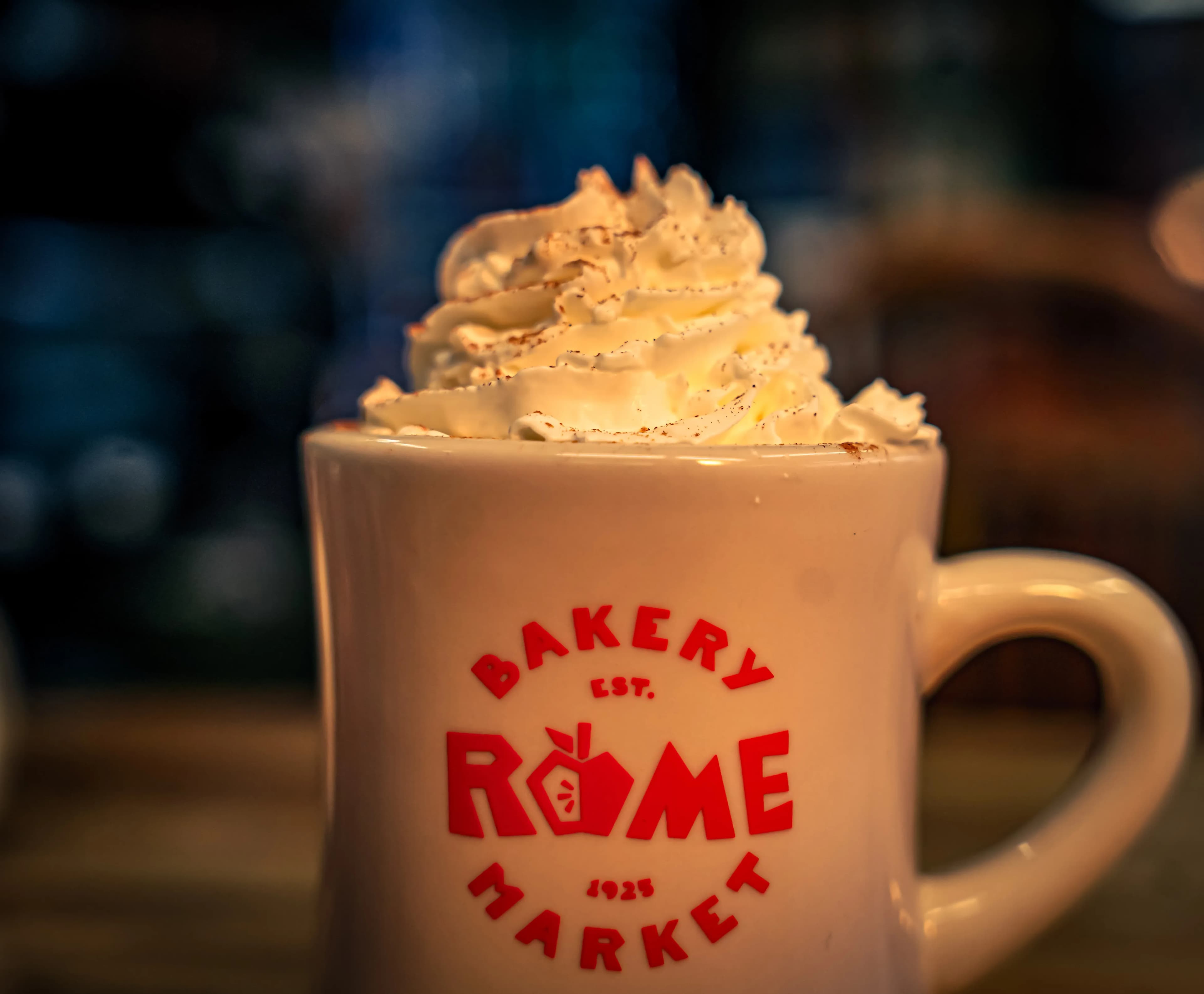 A coffee mug whipped cream on top.