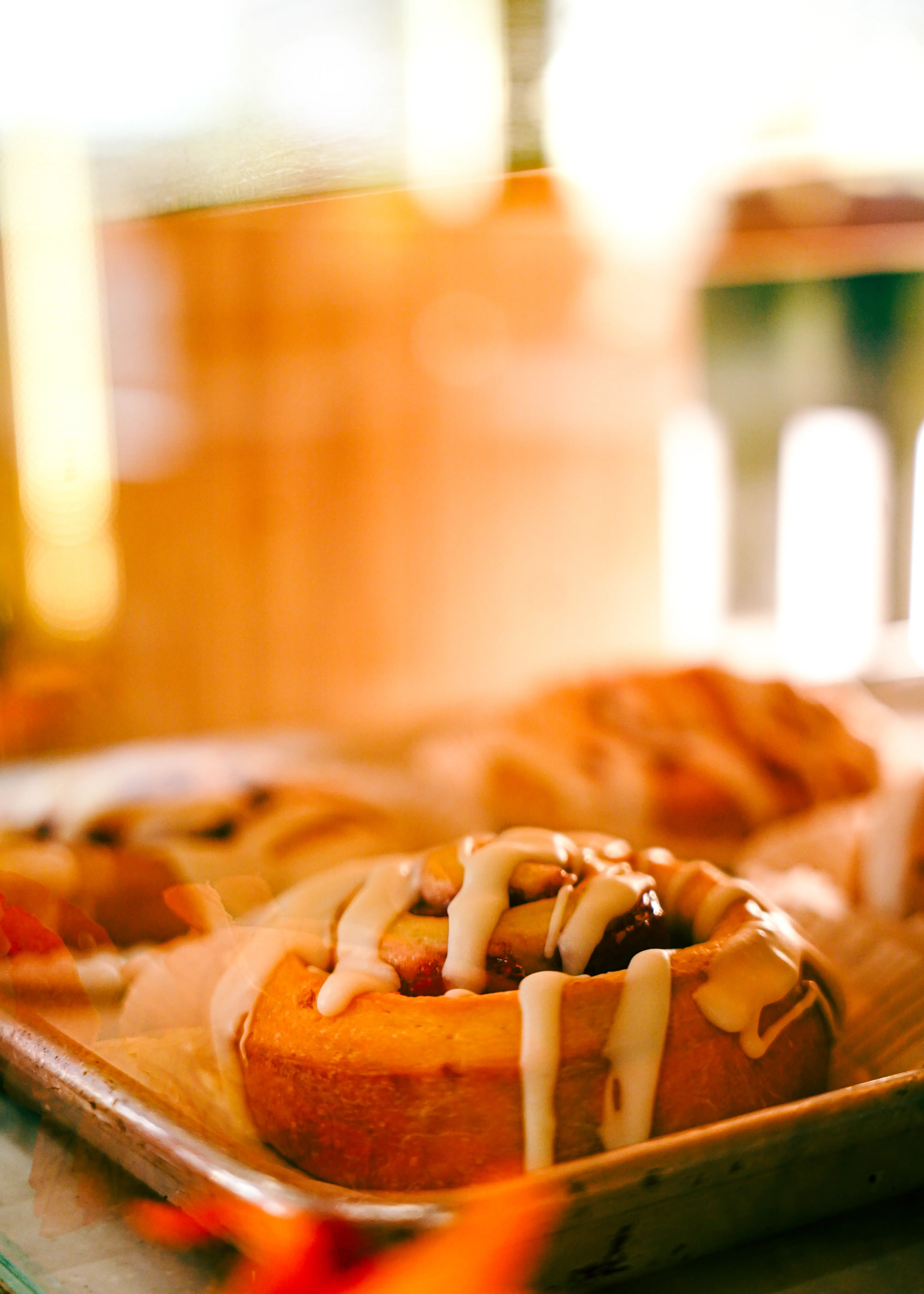A freshly glazed roll inside a pastry case