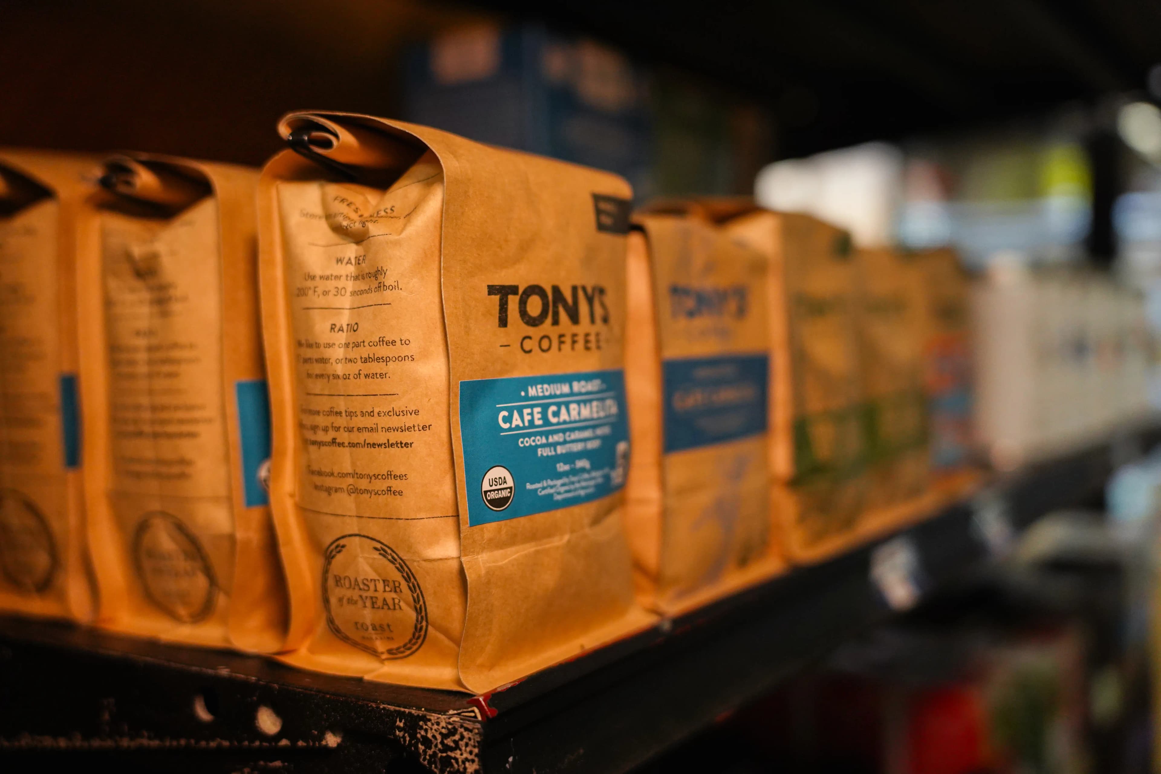 Bags of tony's coffee lined up on a retail shelf.